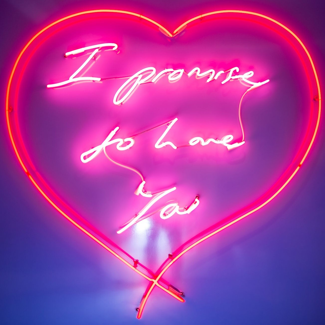 A neon piece of artwork that says "I promise to love you" inside a heart.