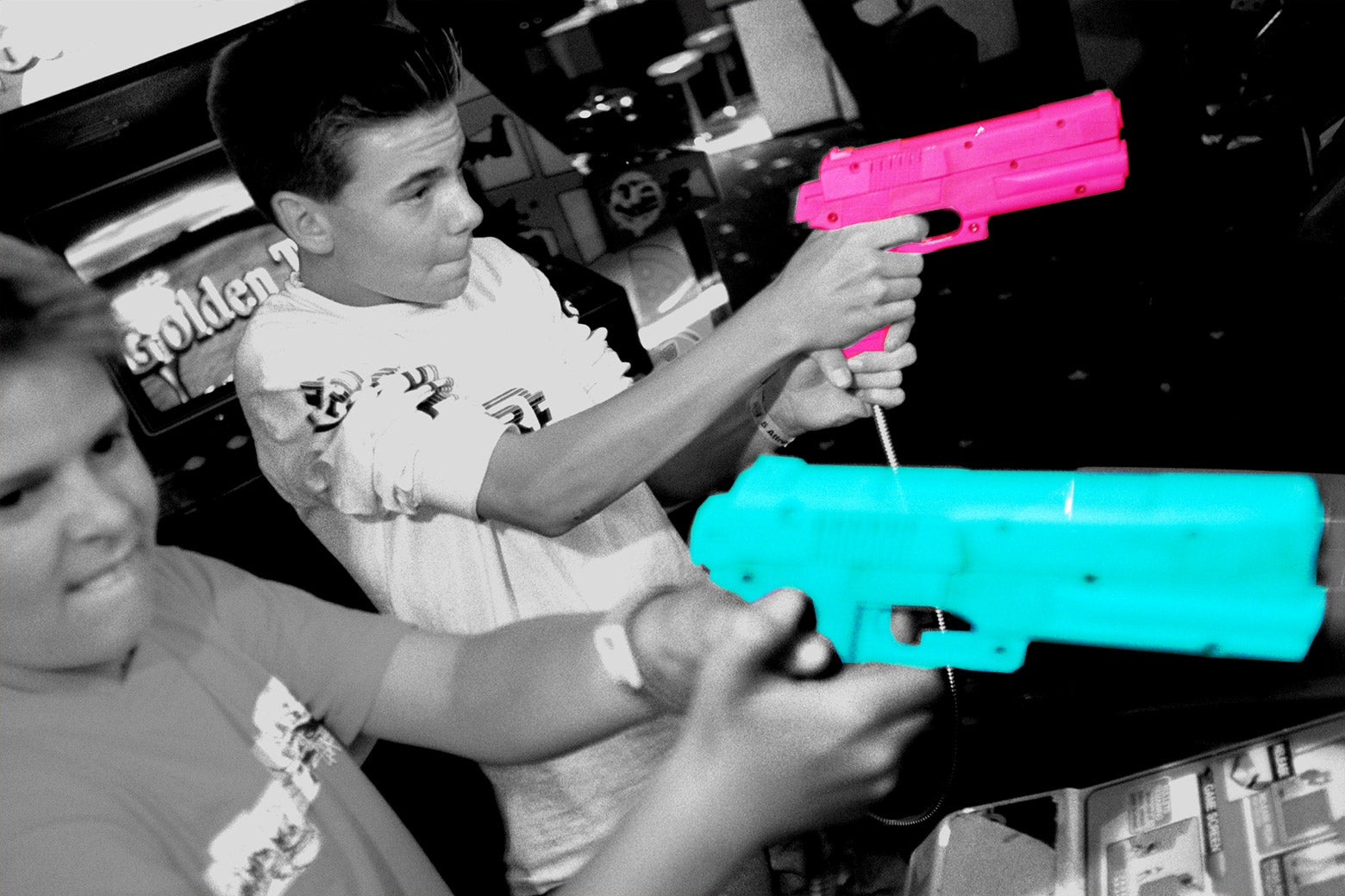 Kids play with toy guns at arcade.