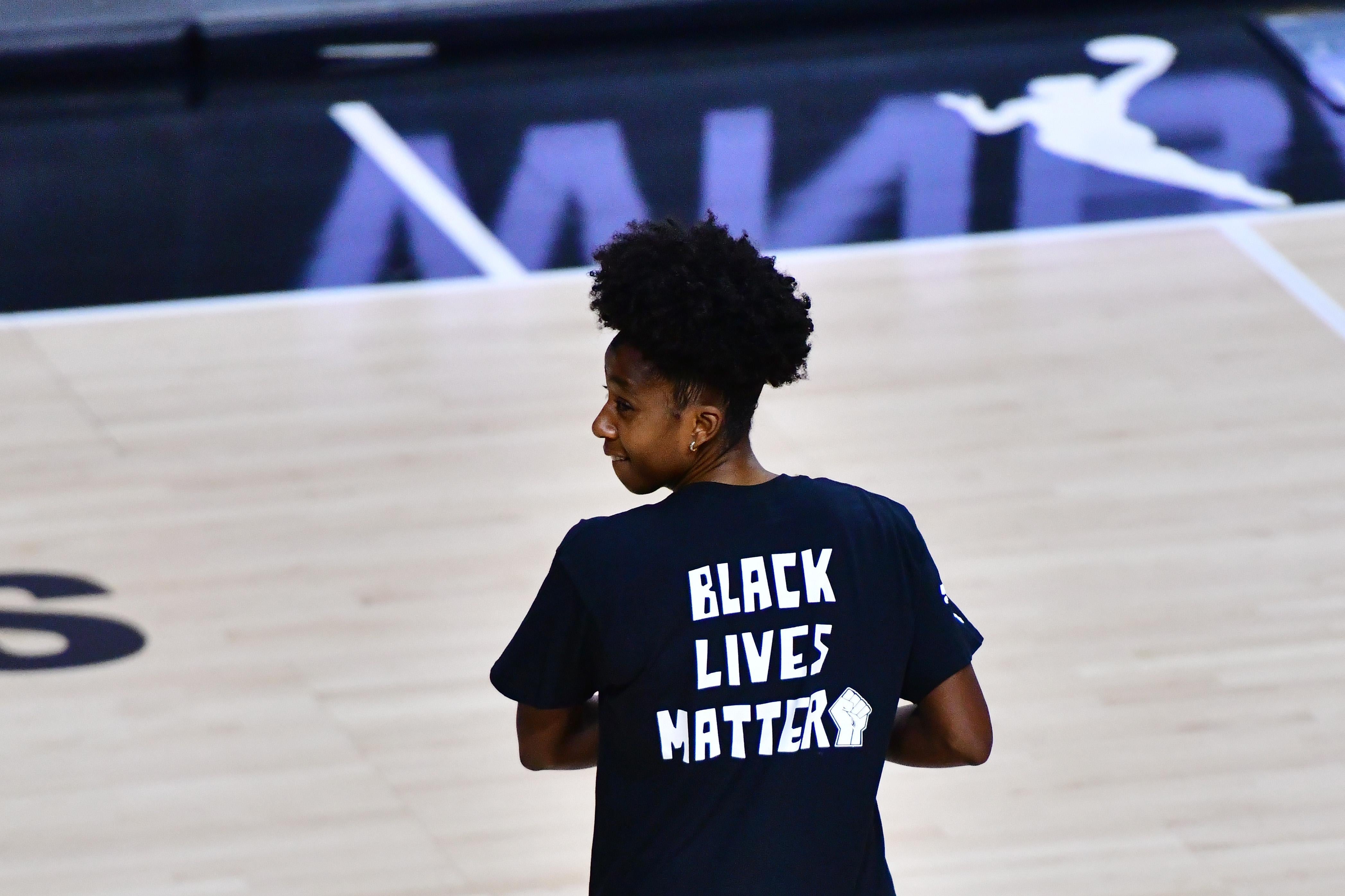 Shenise Johnson is seen on a basketball court wearing a Black Lives Matter shirt.