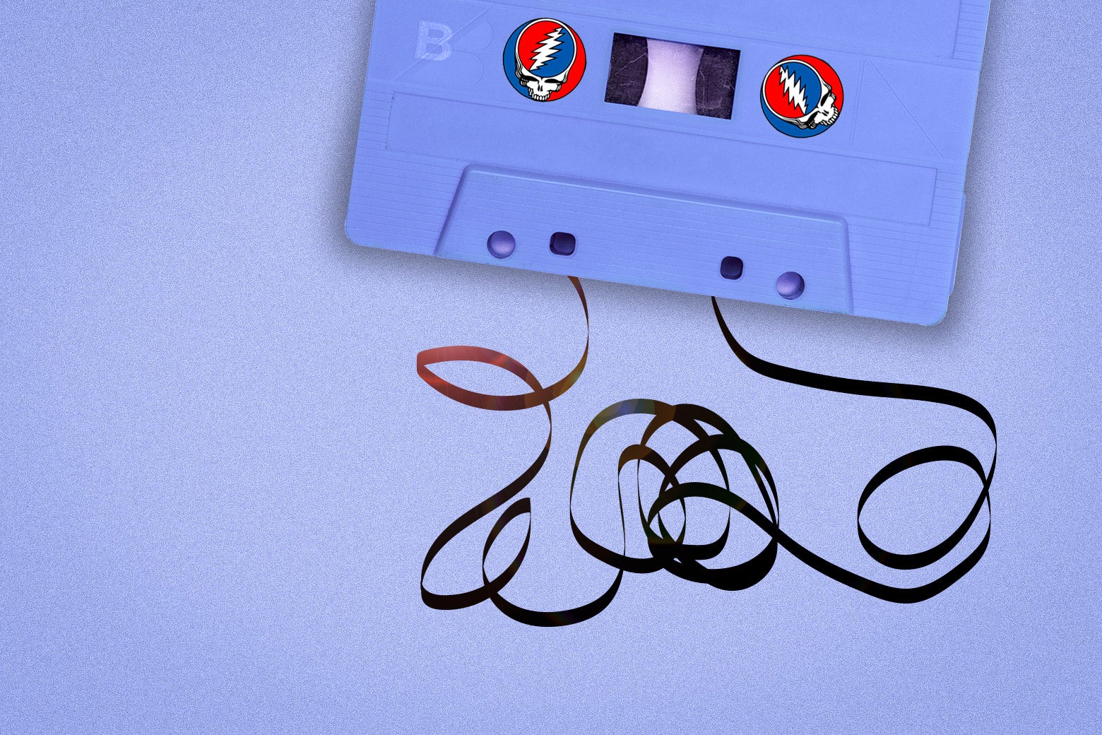 A cassette tape, partially unspooled, with the tape arranged in a Grateful Dead logo.