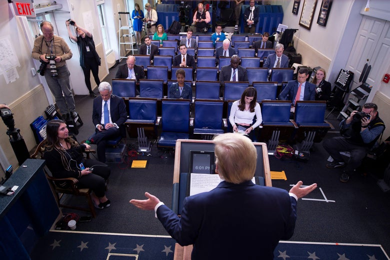 Trump speaks at a podium to a mostly empty press gallery.