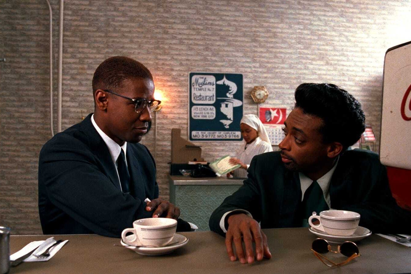 Two men sitting together at a diner having coffee.