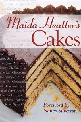 A book cover with a yellow layer cake with chocolate frosting. Maida Heatter's Cakes, foreword by Nancy Silverton.