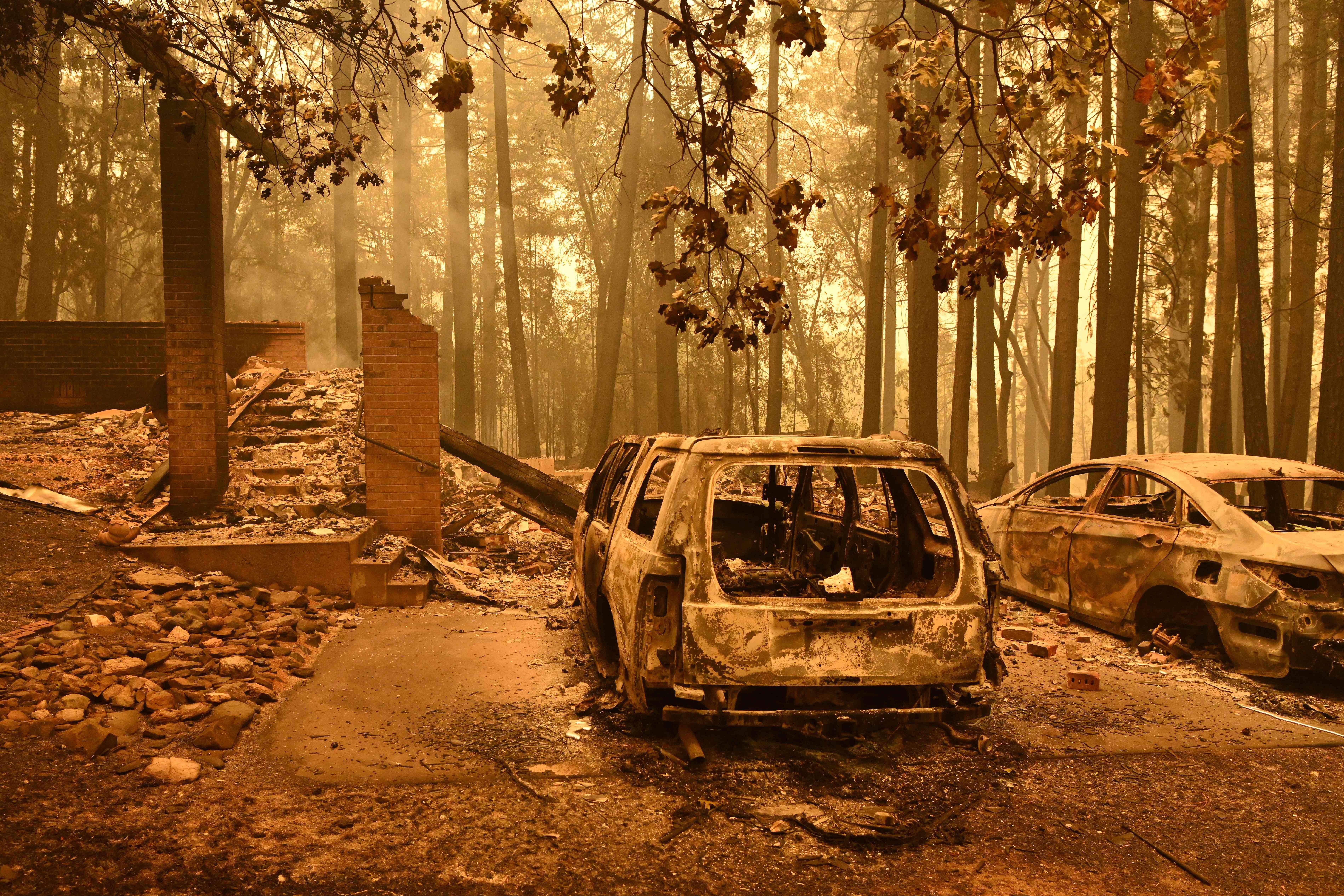 Burned vehicles smolder at a property during the Dixie Fire in the Indian Falls area of unincorporated Plumas County on July 25, 2021. 