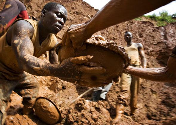 Gold miners in northeastern Congo form a human chain while digging an open pit.