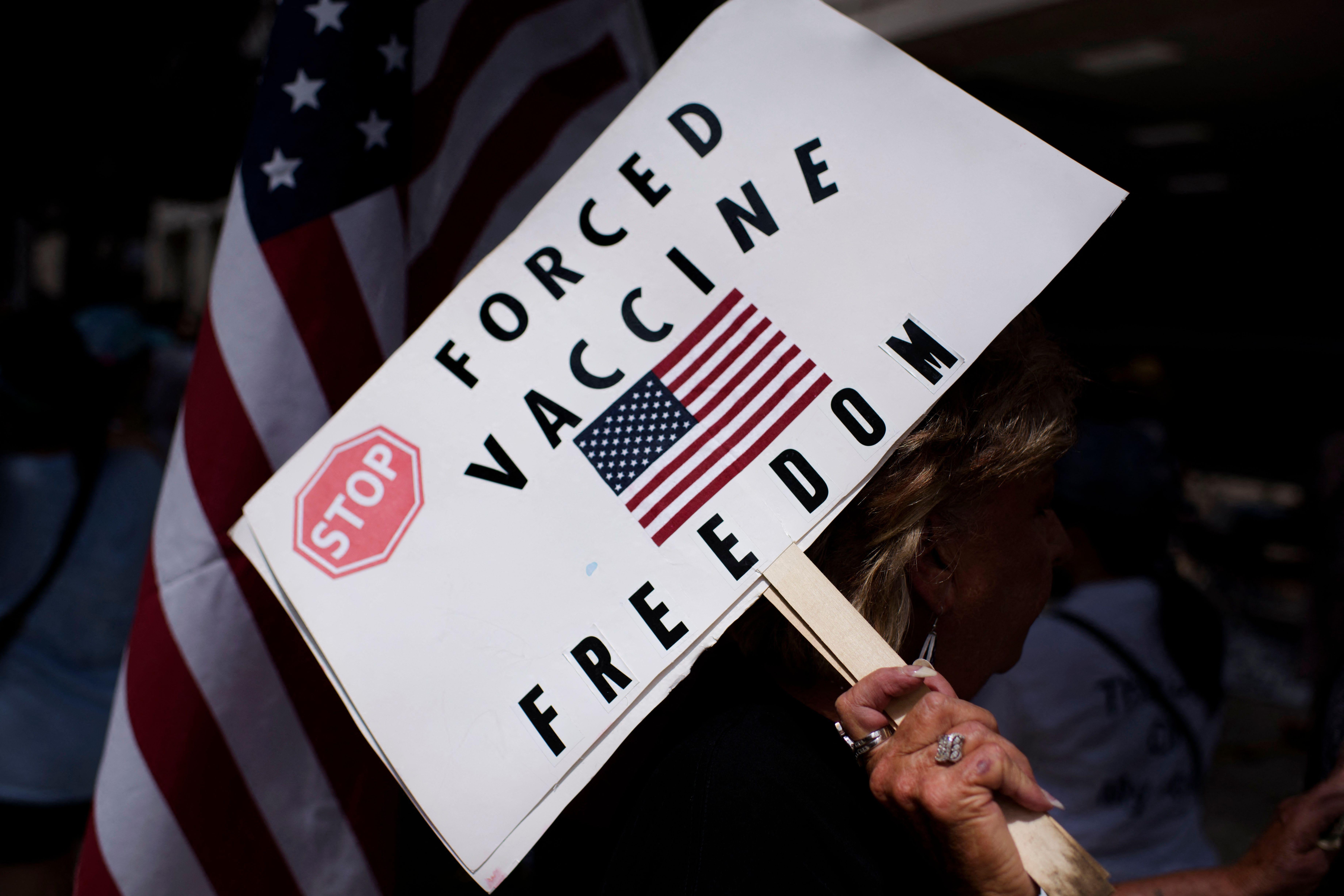 A sign featuring a U.S. flag and reading "Stop Forced Vaccine. Freedom."