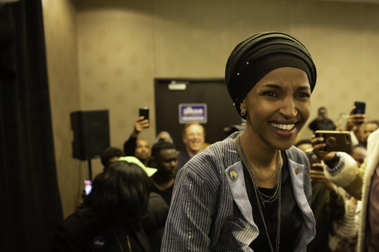 Ilhan Omar smiling, with a crowd behind her.