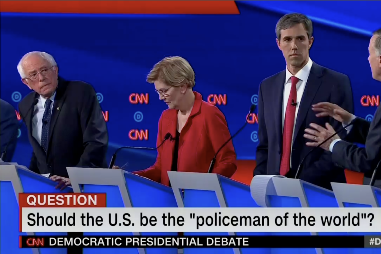 Bernie Sanders, Elizabeth Warren, and Beto O'Rourke are shown in this screengrab from CNN. The banner reads: "Should the U.S. be the 'policeman of the world'?"