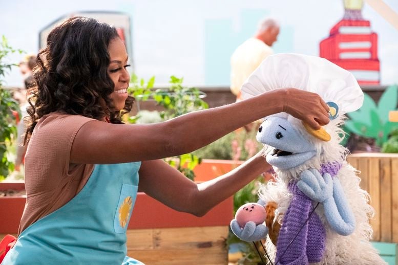 Michelle Obama puts a toque on Waffles' head as Waffles holds Mochi in her hand