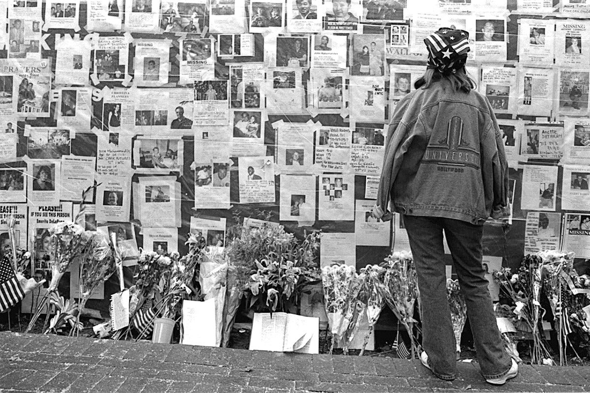 A young woman looks at one of the many displays with photos of the missing on a wall.