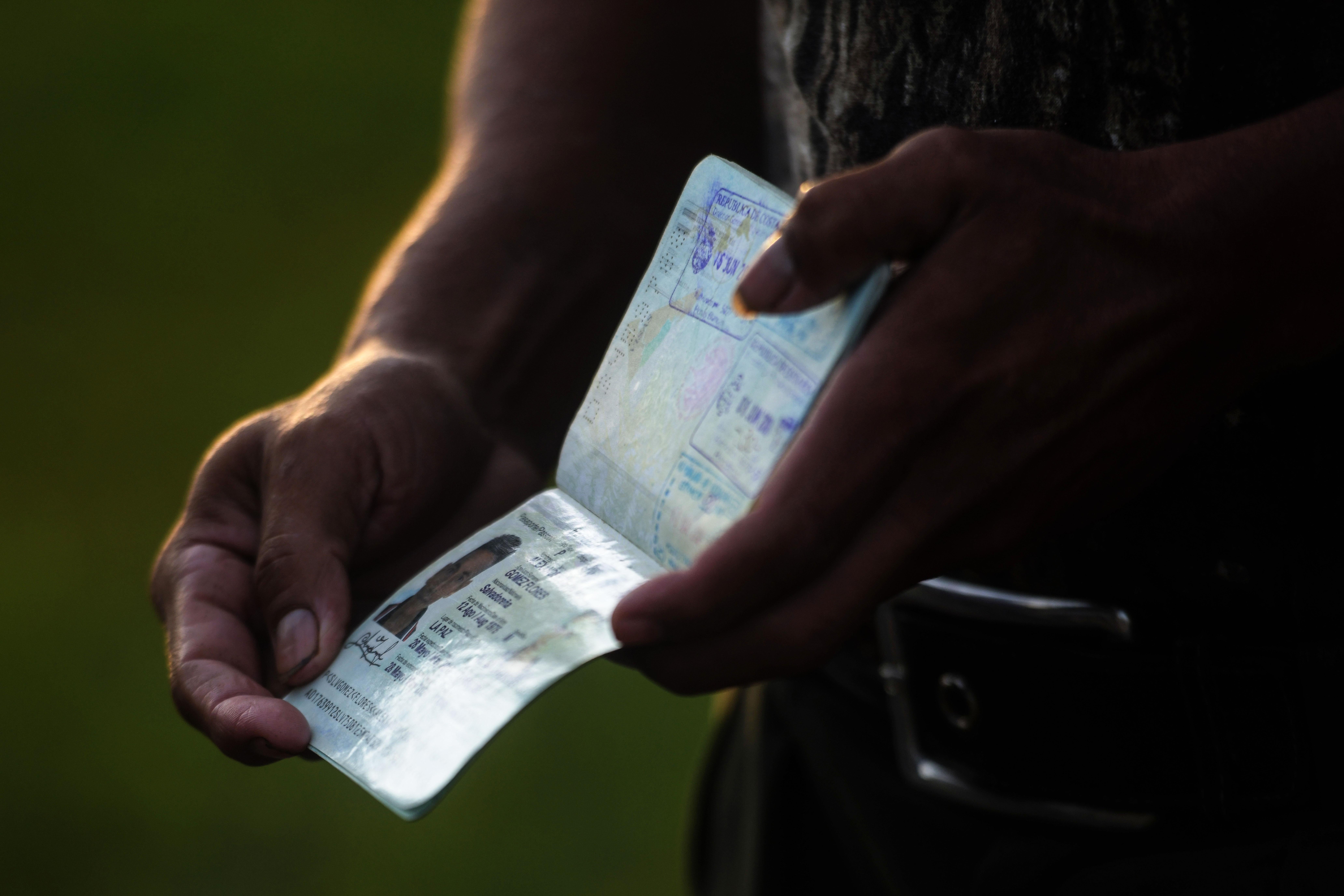 A Salvadoran migrant shows his passport as he gathers in a caravan in San Salvador to start a journey towards the U.S. on Oct. 28, 2018.