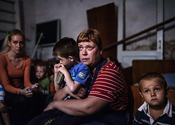 Children and their educators hide in a bomb shelter in an orphanage during a shelling in the town of Makiyivka on August 19, 2014. 