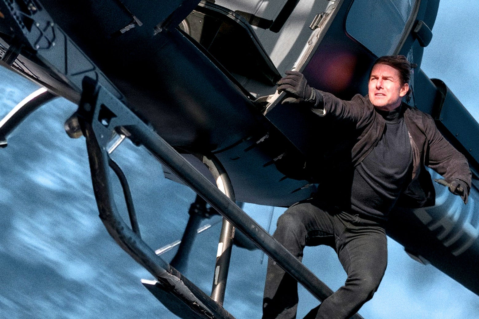Tom Cruise attempting to hold fast to the outside of a helicopter in Mission: Impossible - Fallout.