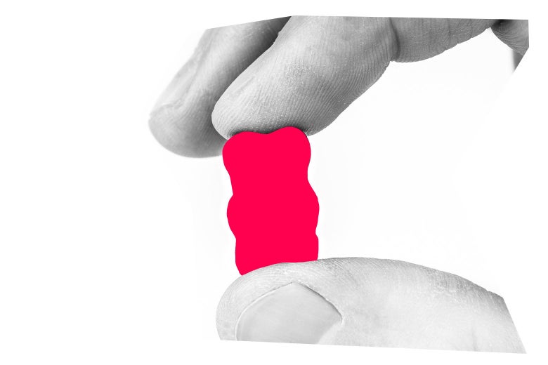 Close-up of fingers holding a gummy bear.
