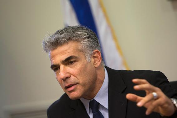 Israel's Finance Minister Yair Lapid gestures as he speaks during a Yesh Atid party meeting at the Knesset, the Israeli parliament, in Jerusalem, May 20, 2013. 