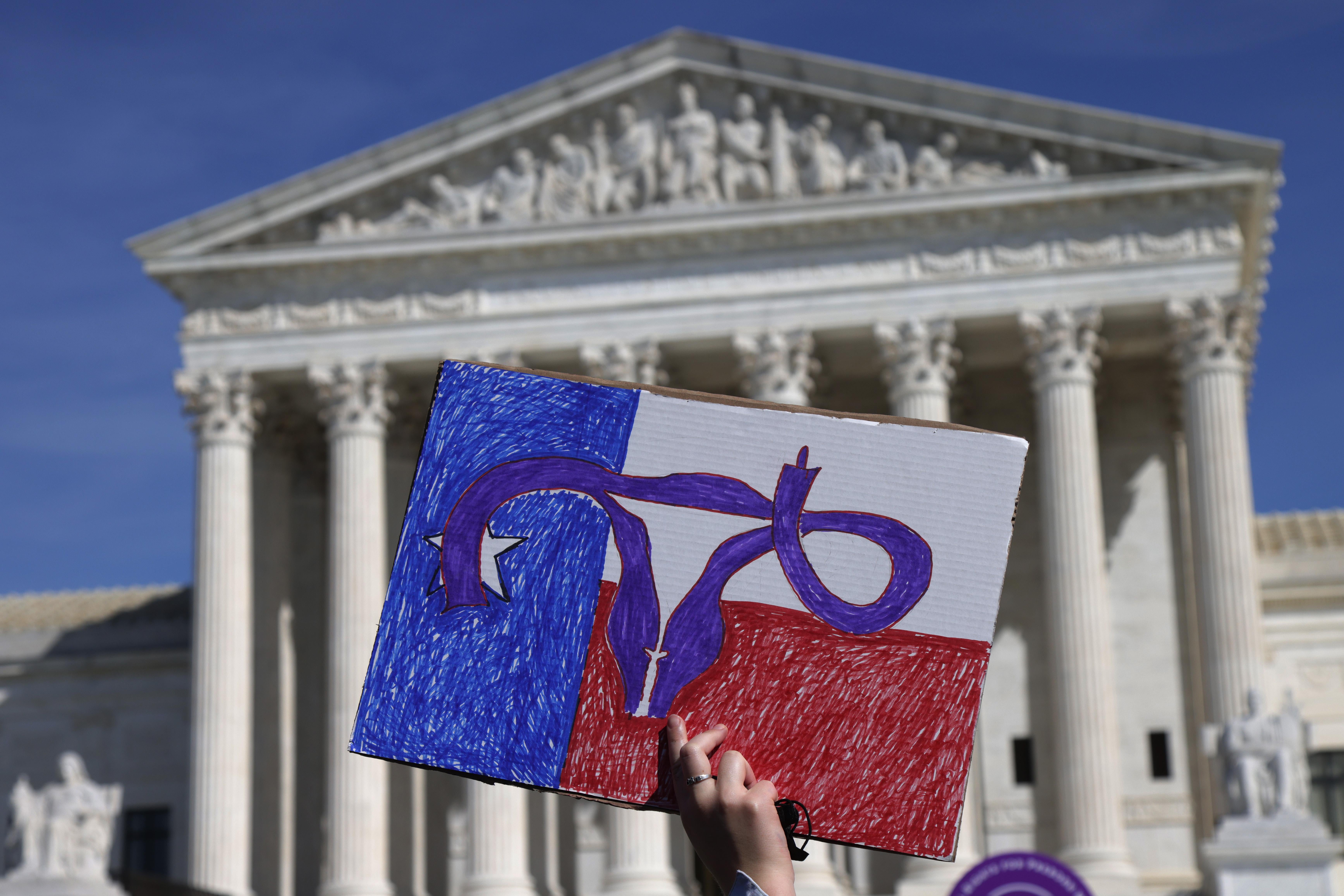 A women rights activist holds up a sign during the annual Women’s March in front of the U.S. Supreme Court October 2, 2021 in Washington, D.C.