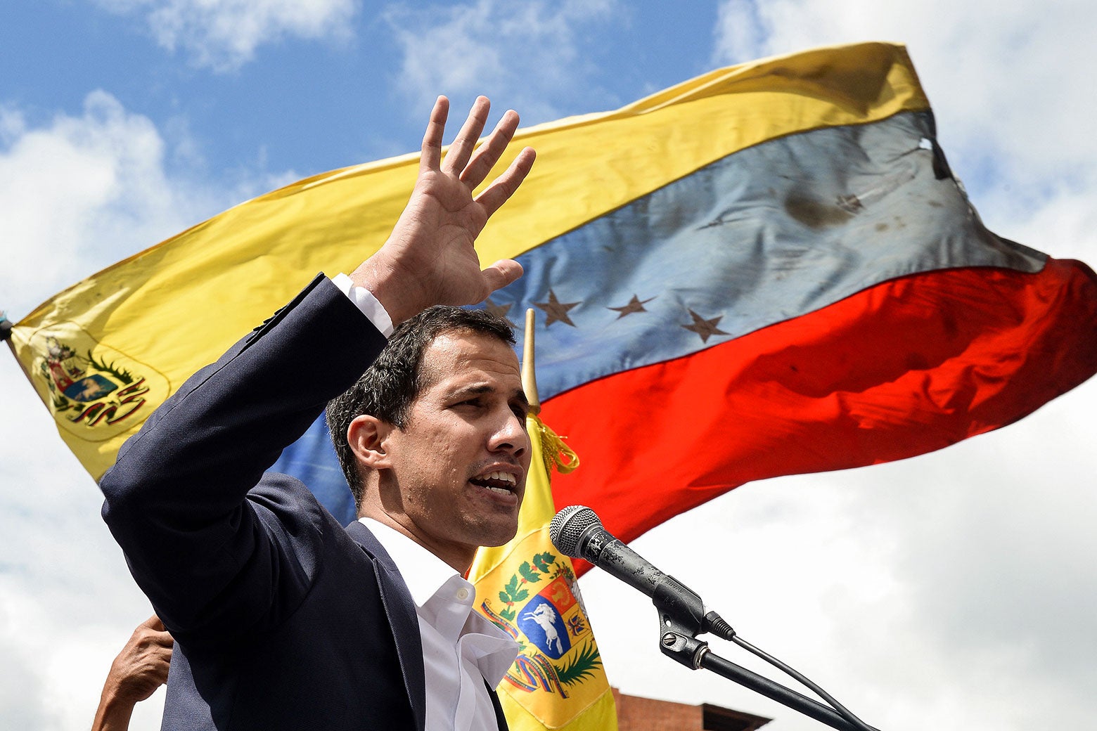Juan Guaidó speaks in front of a Venezuelan flag.