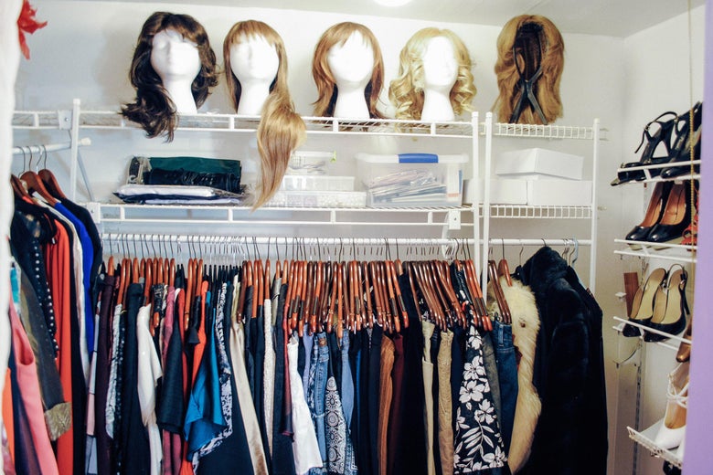 A closet containing women’s clothing, wigs, and shoes.