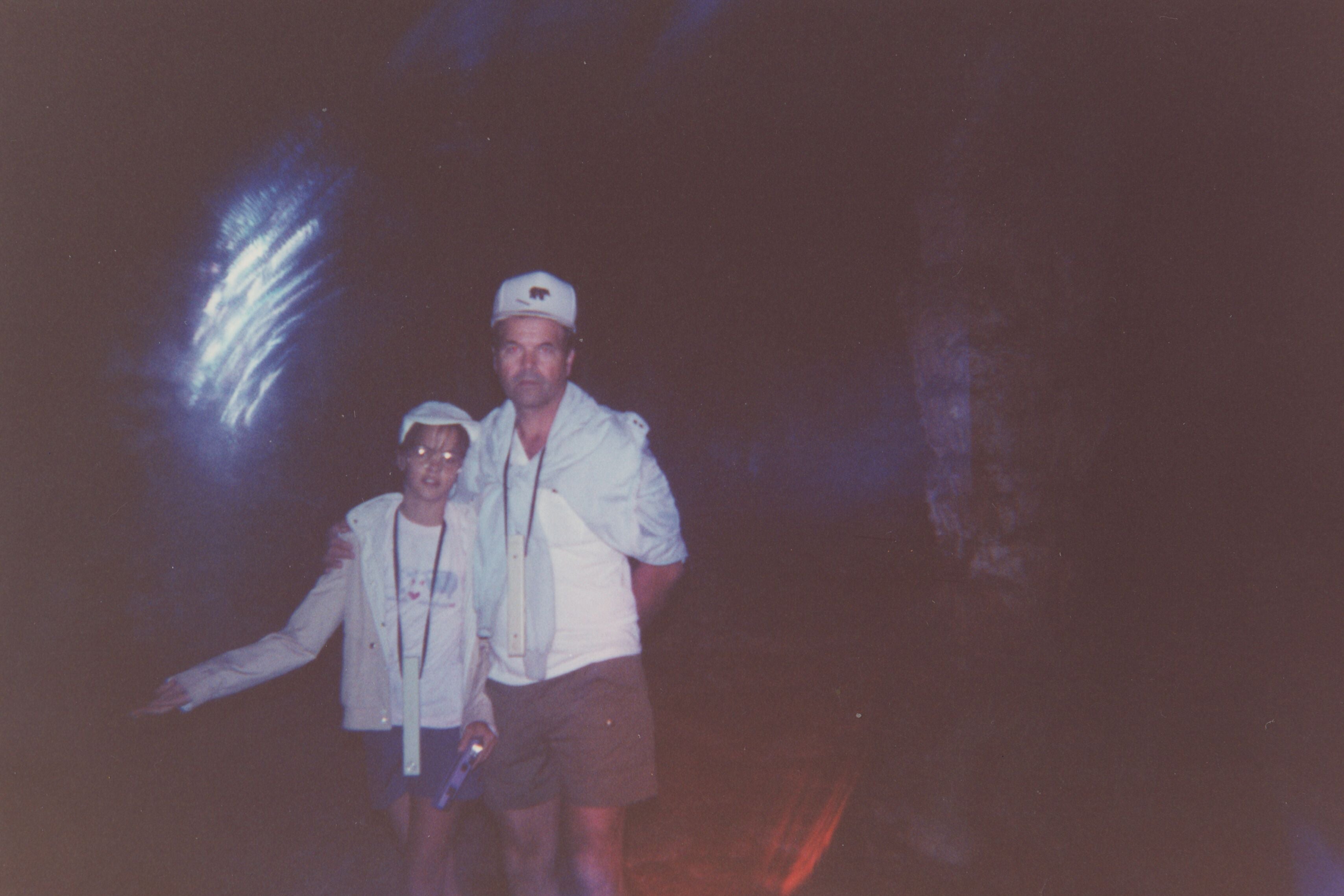 Kerri Rawson and her father in a dark space with a spectral burst of light hovering next to their heads.