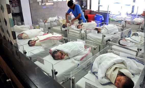An Indian nurse cares for new born babies in a nursery at a maternity hospital in Kolkata in September 2010.