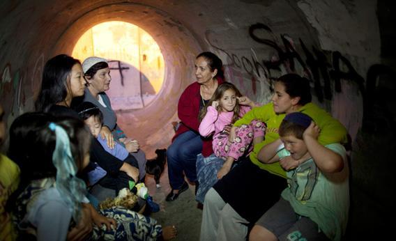 Israelis take cover in a large concrete pipe used as a bomb shelter after a rocket was launched from the Gaza Strip.