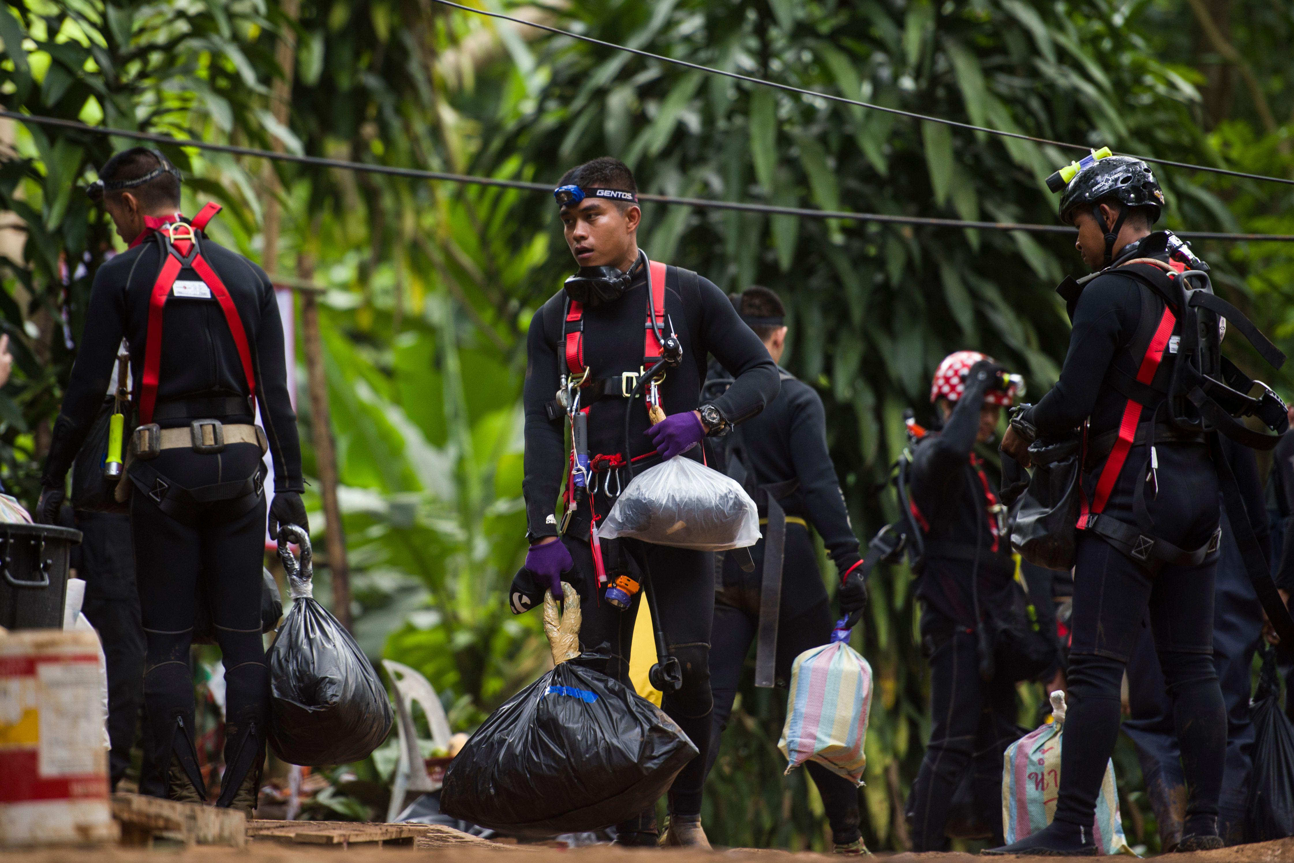 Thai divers carry supplies as rescue operations continue for 12 boys and their coach trapped at Tham Luang cave at Khun Nam Nang Non Forest Park in the Mae Sai district of Chiang Rai province on July 5, 2018. - Thai rescuers vowed to take a 'no risk' approach to freeing 12 boys and their football coach from a flooded cave, as fresh video emerged on July 4 showing the team in good spirits following their astonishing discovery nine days after going missing. (Photo by YE AUNG THU / AFP)        (Photo credit should read YE AUNG THU/AFP/Getty Images)
