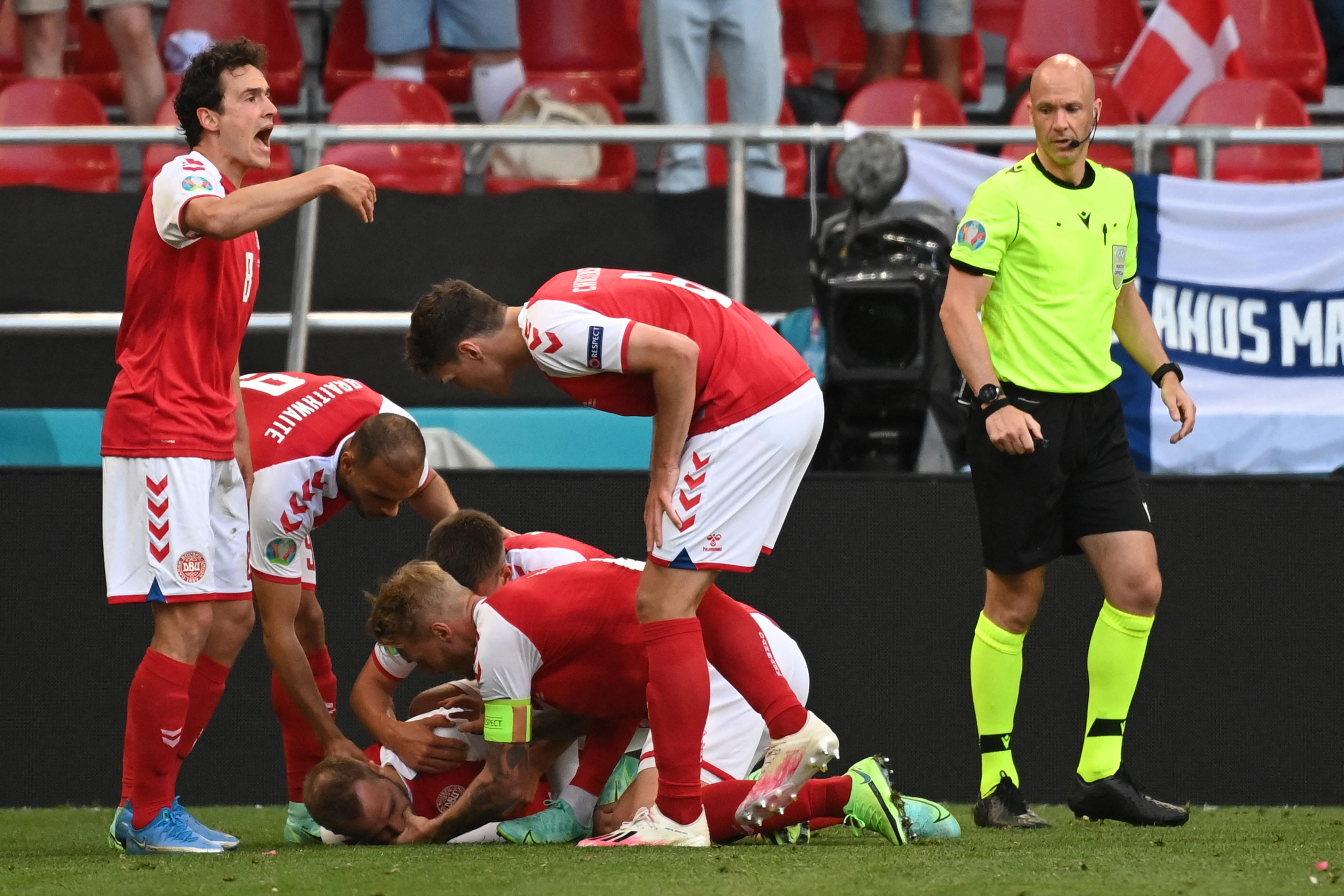 Denmark players help Denmark's midfielder Christian Eriksen after he collapsed during the UEFA EURO 2020 Group B football match between Denmark and Finland at the Parken Stadium in Copenhagen on June 12, 2021. 