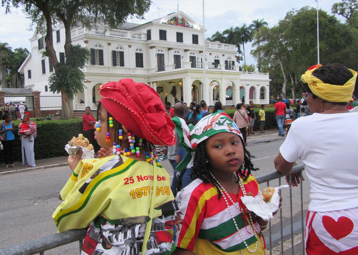 Children wait for the military parade in front of Suriname's presidential palace.