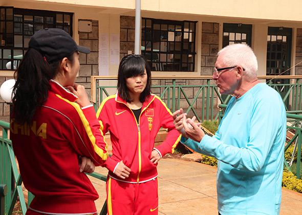 Coach Renato Canova talks with athlete Wang Mei via interpreter Anna Lin.