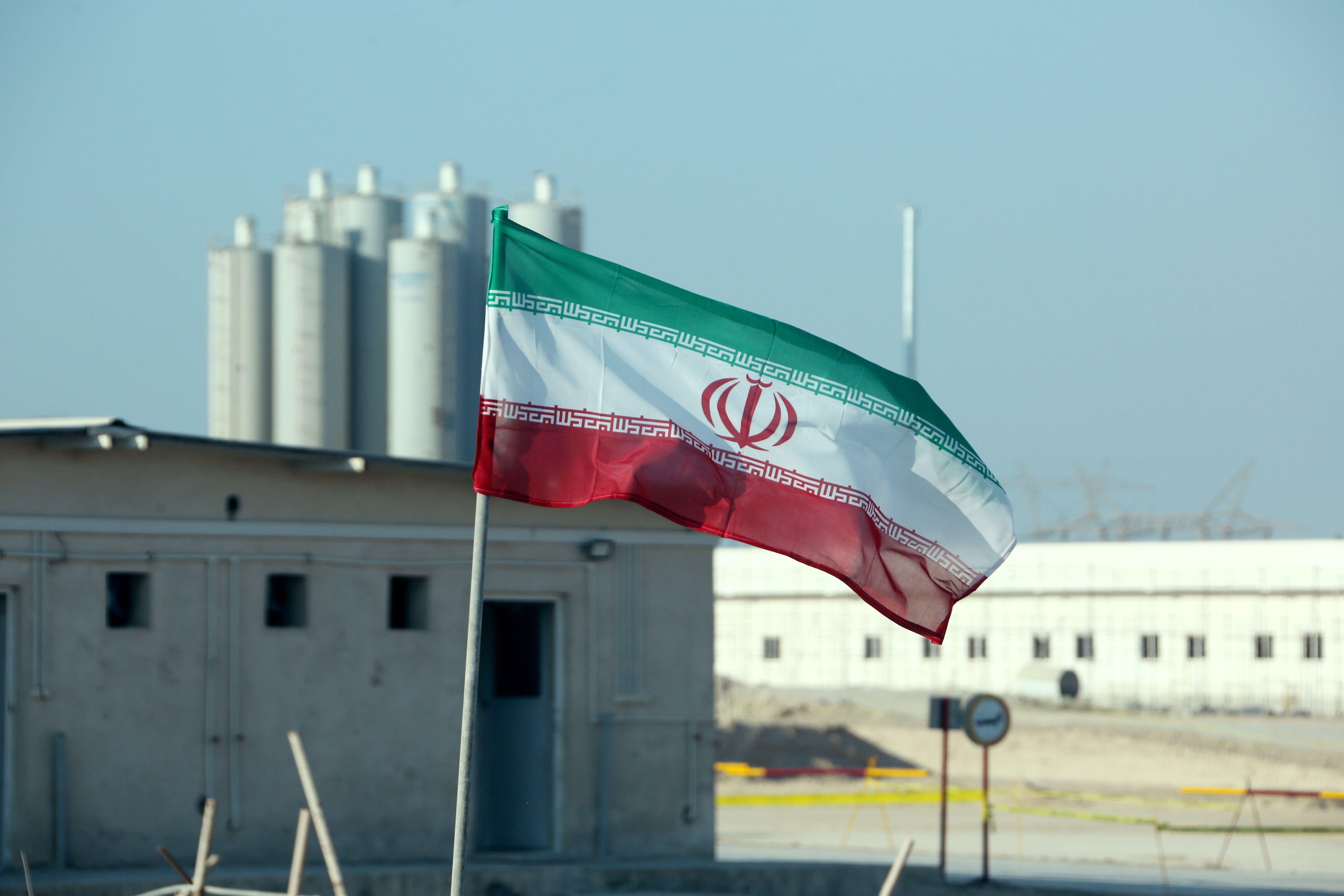 An Iranian flag flying in front of a nuclear power plant.