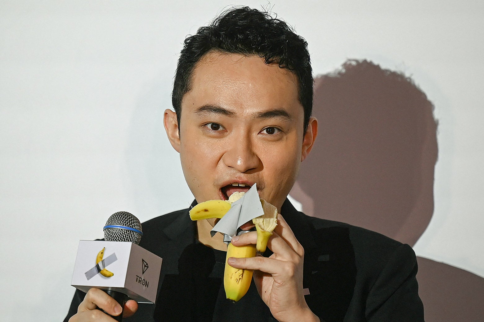 Justin Sun eats a banana artwork composed of a fresh banana stuck to a wall with duct tape, in Hong Kong on Nov. 29 after buying the provocative work of conceptual art by Italian artist Maurizio Cattelan at a New York auction for $6.2 million.