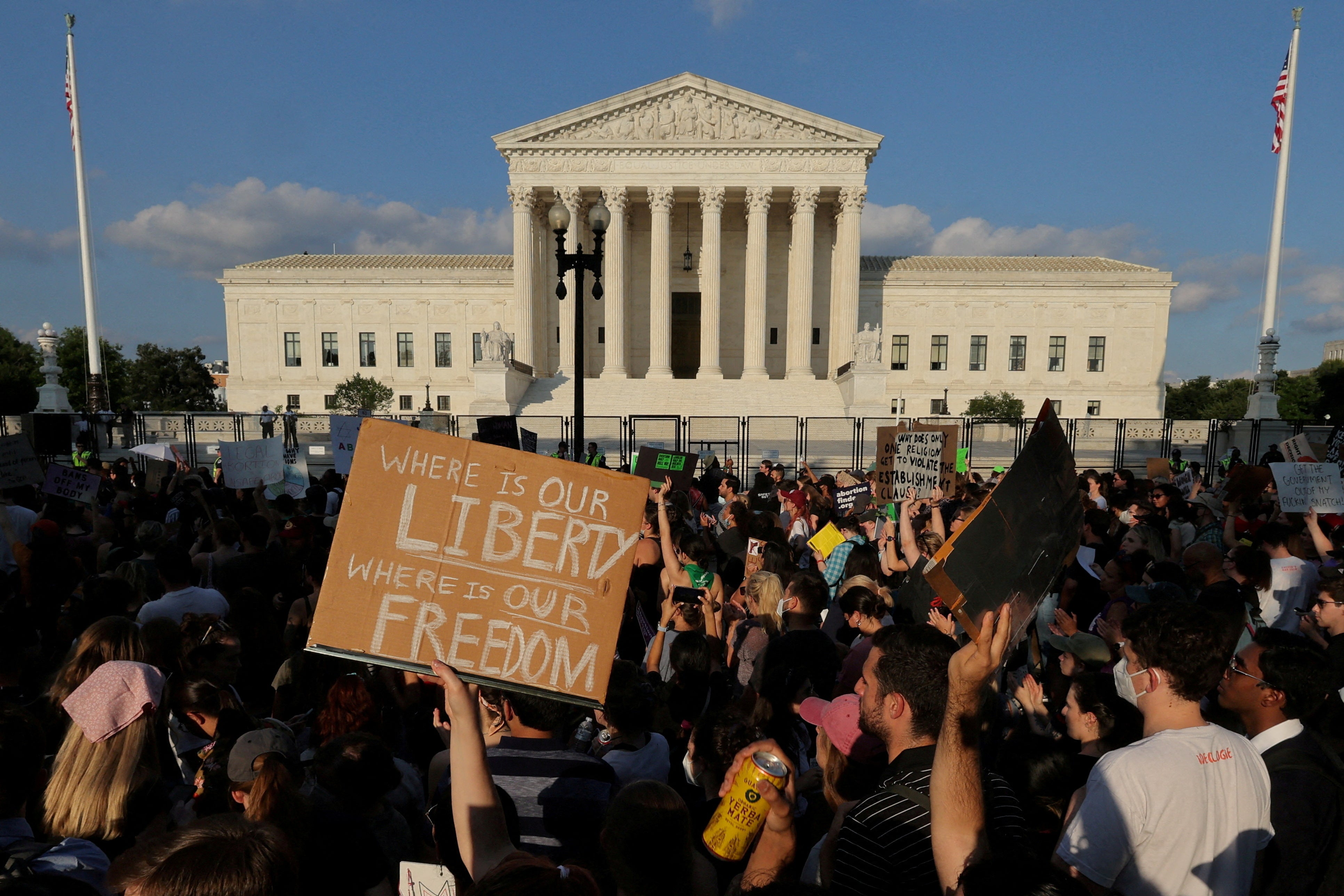 Protesters gather outside the fence around the Supreme Court building.
