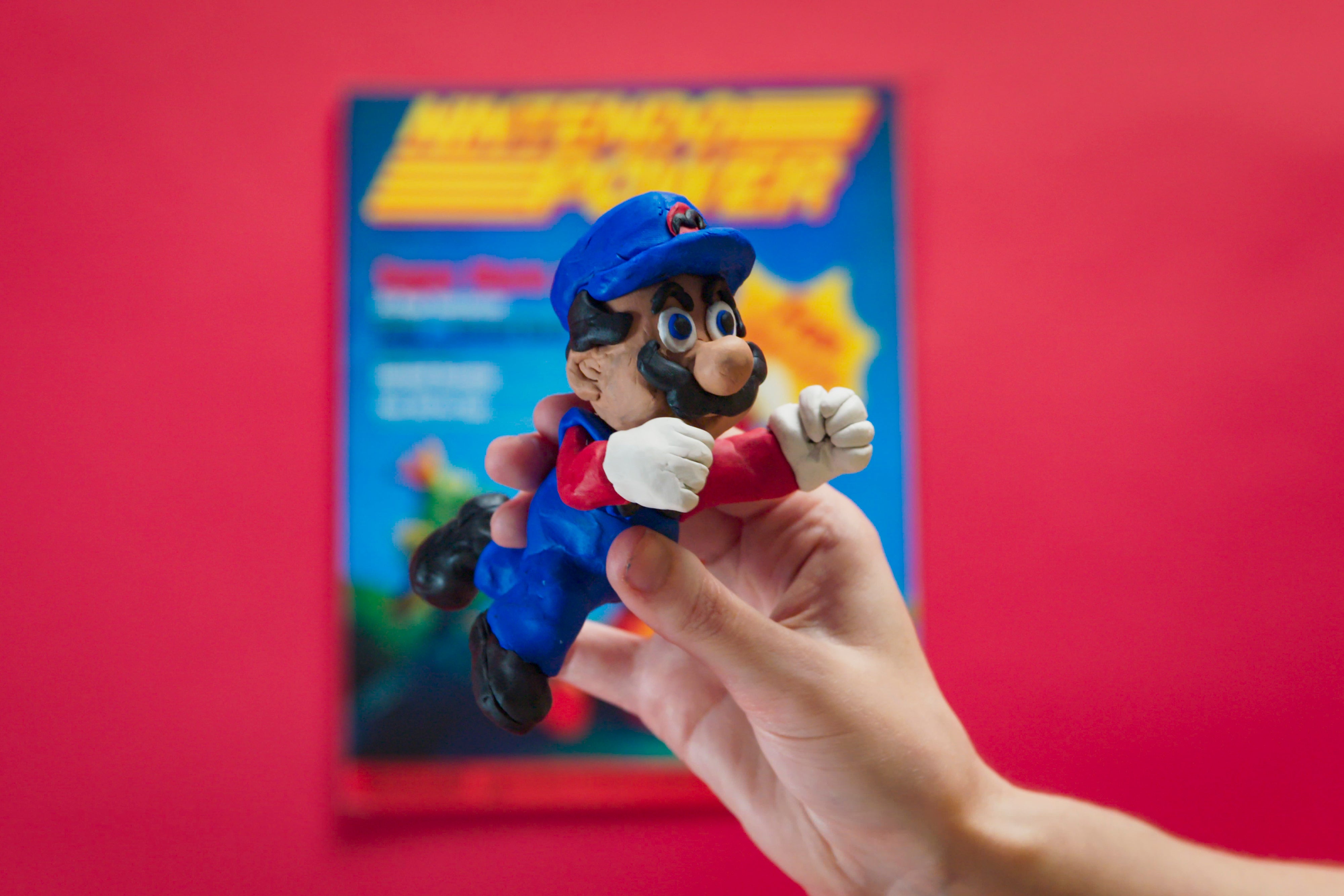 A Mario figurine in front of an old copy of Nintendo Power