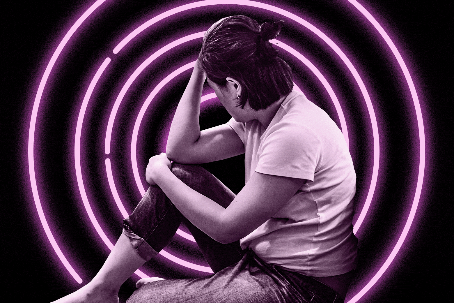 Woman sitting down with her head in her hands in front of flashing circles