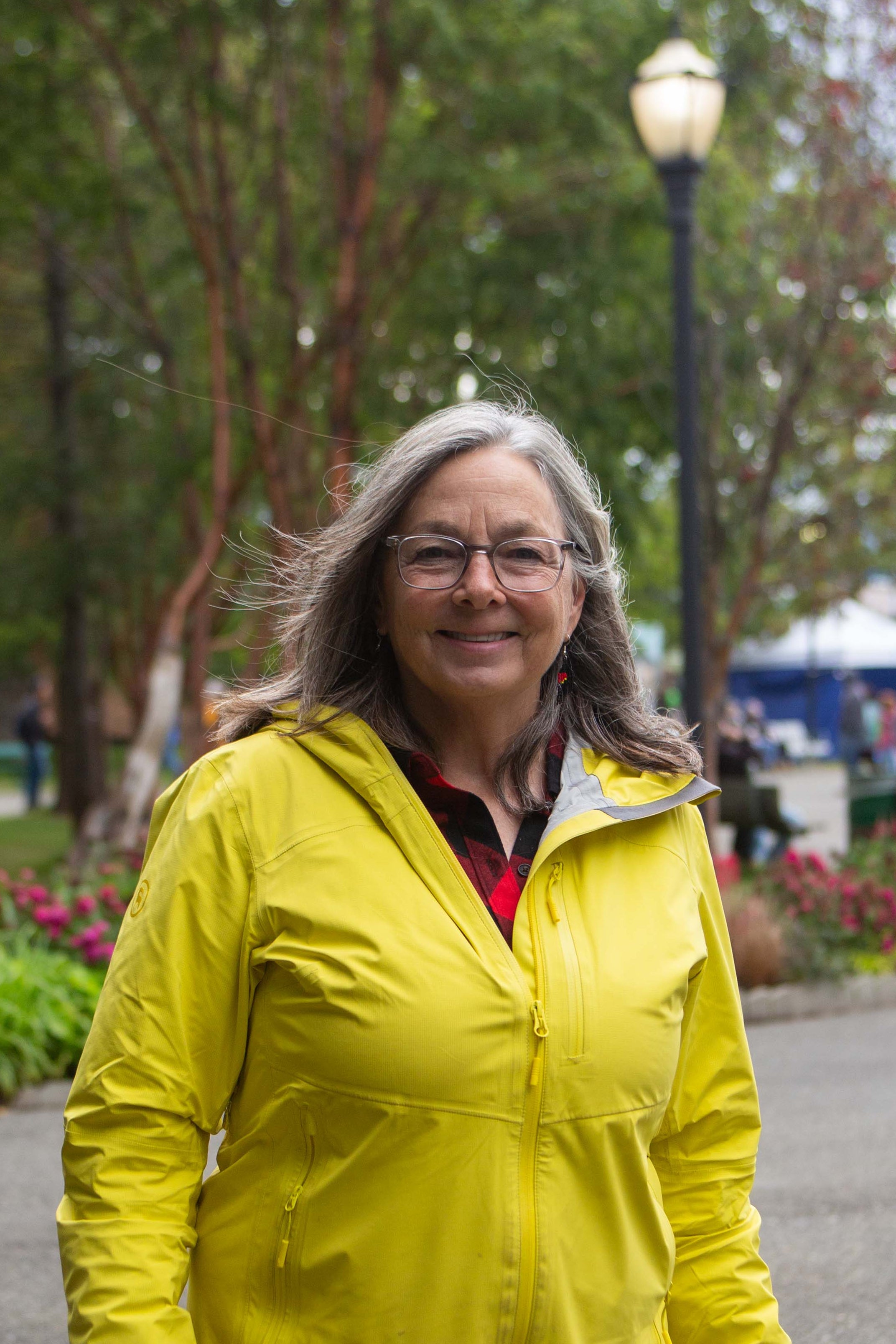 A portrait of a woman outside in a yellow raincoat.