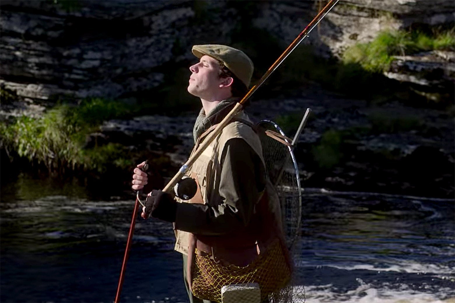 A still from The Crown in which Josh O'Connor as Prince Charles fishing, very incompetently.