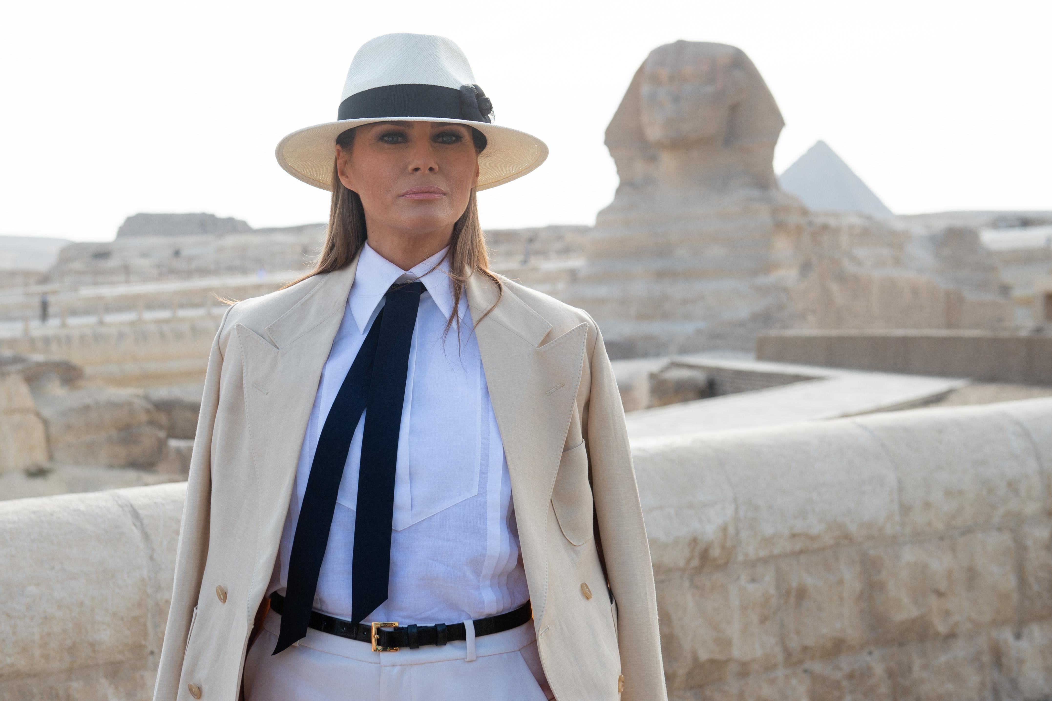 Melania, dressed in white and linen, poses for the camera in front of the Sphinx. 