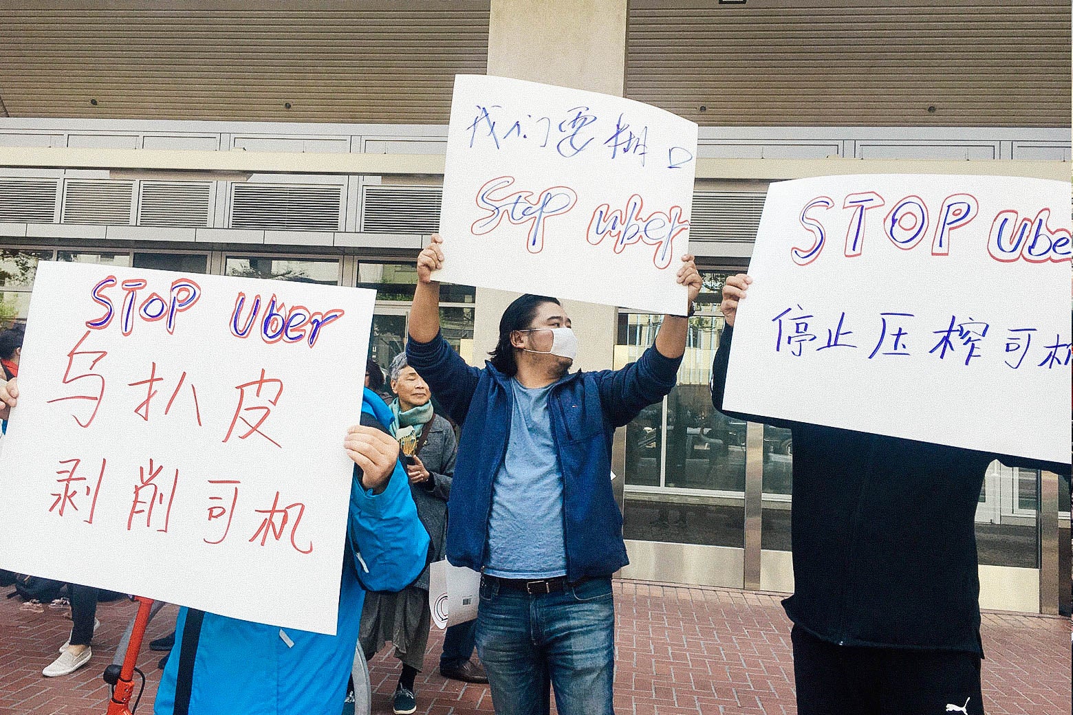 Protesters holding anti-Uber signs in Chinese.