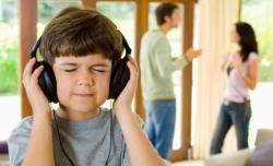 Boy listening to headphones while parents fight.