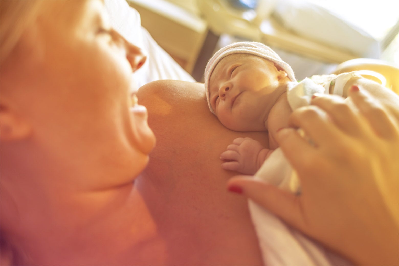 A mother holds a newborn baby in the hospital.