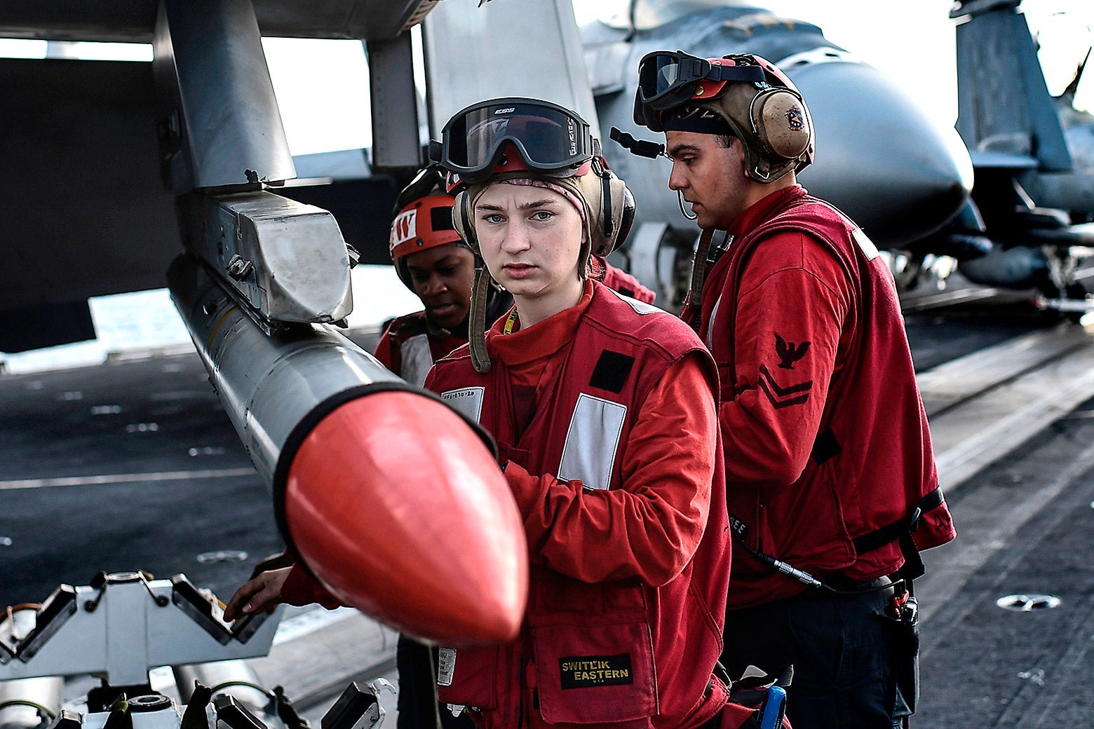 Two aircraft operators carry a missile.