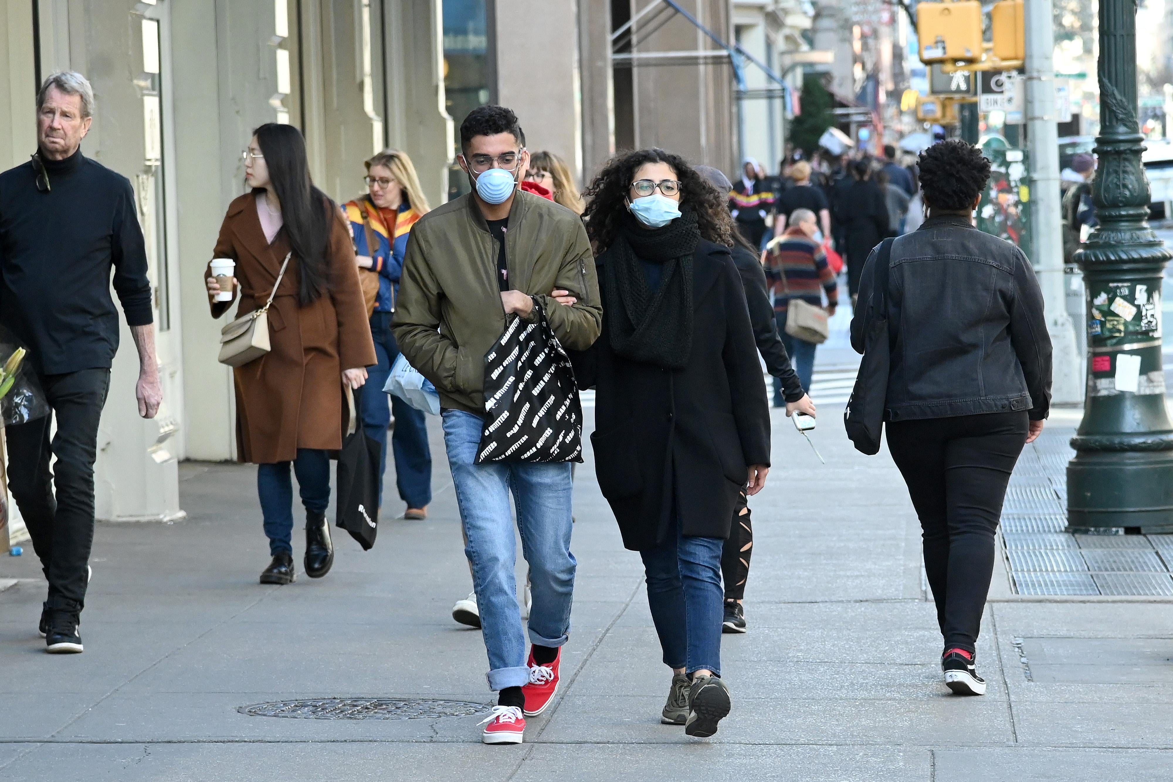 People wearing masks are seen as the coronavirus continues to spread across the United States on March 14, 2020 in New York City.