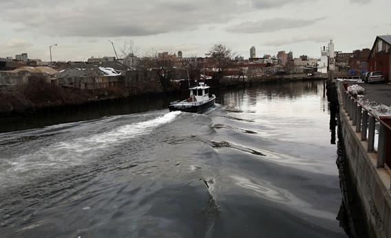 A boat navigates down the Gowanus Canal in Brooklyn, New York.