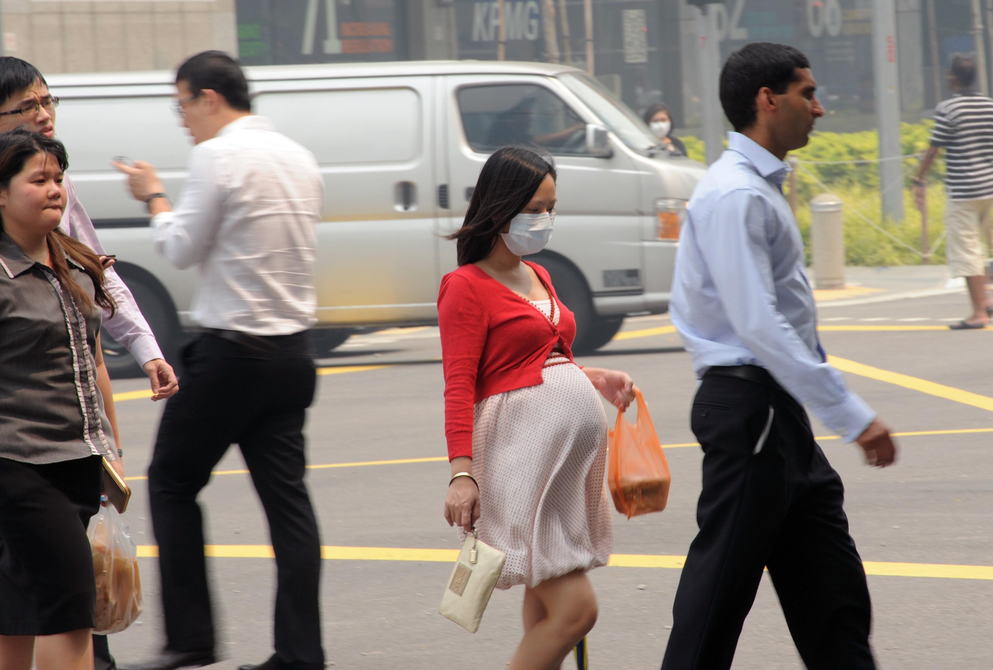 A pregnant woman with a face mask walking on the street in Singapore, June 20, 2013.