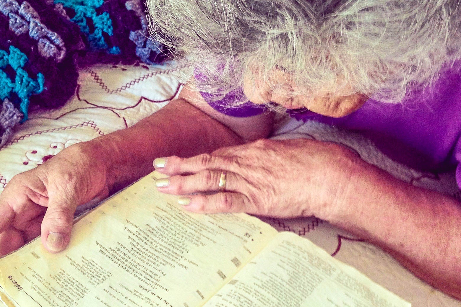 A woman leans over a Bible.