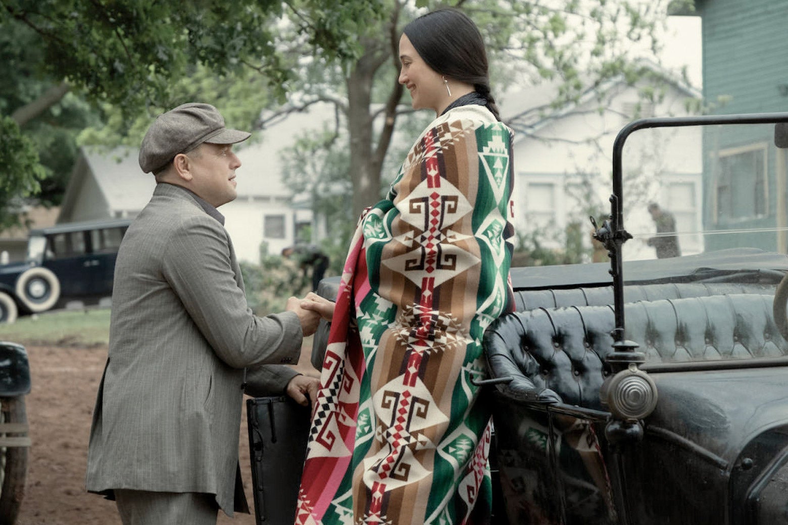 Leonardo DiCaprio helps Lily Gladstone down from a 1920s car in a scene from the movie. 