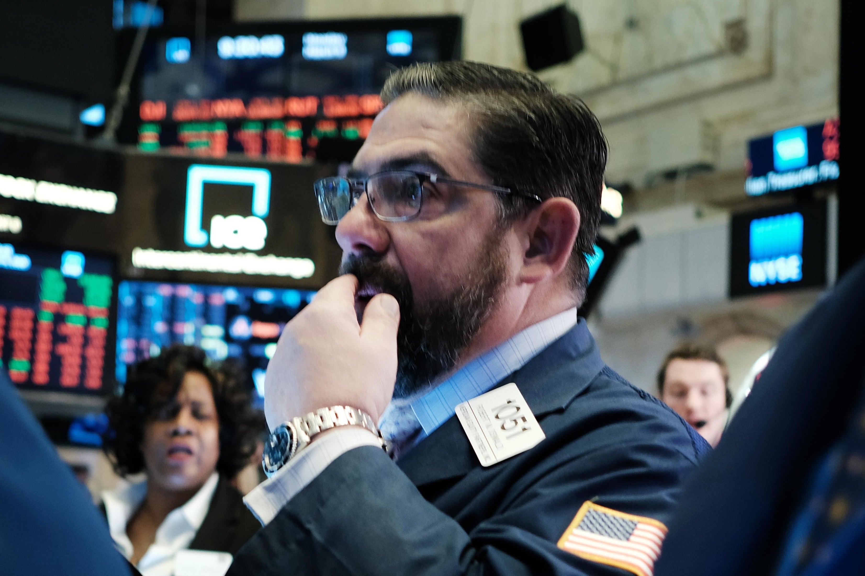 A bearded man puts his hand over his mouth