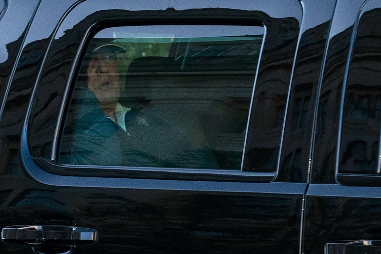 Trump is seen in the back of a car.