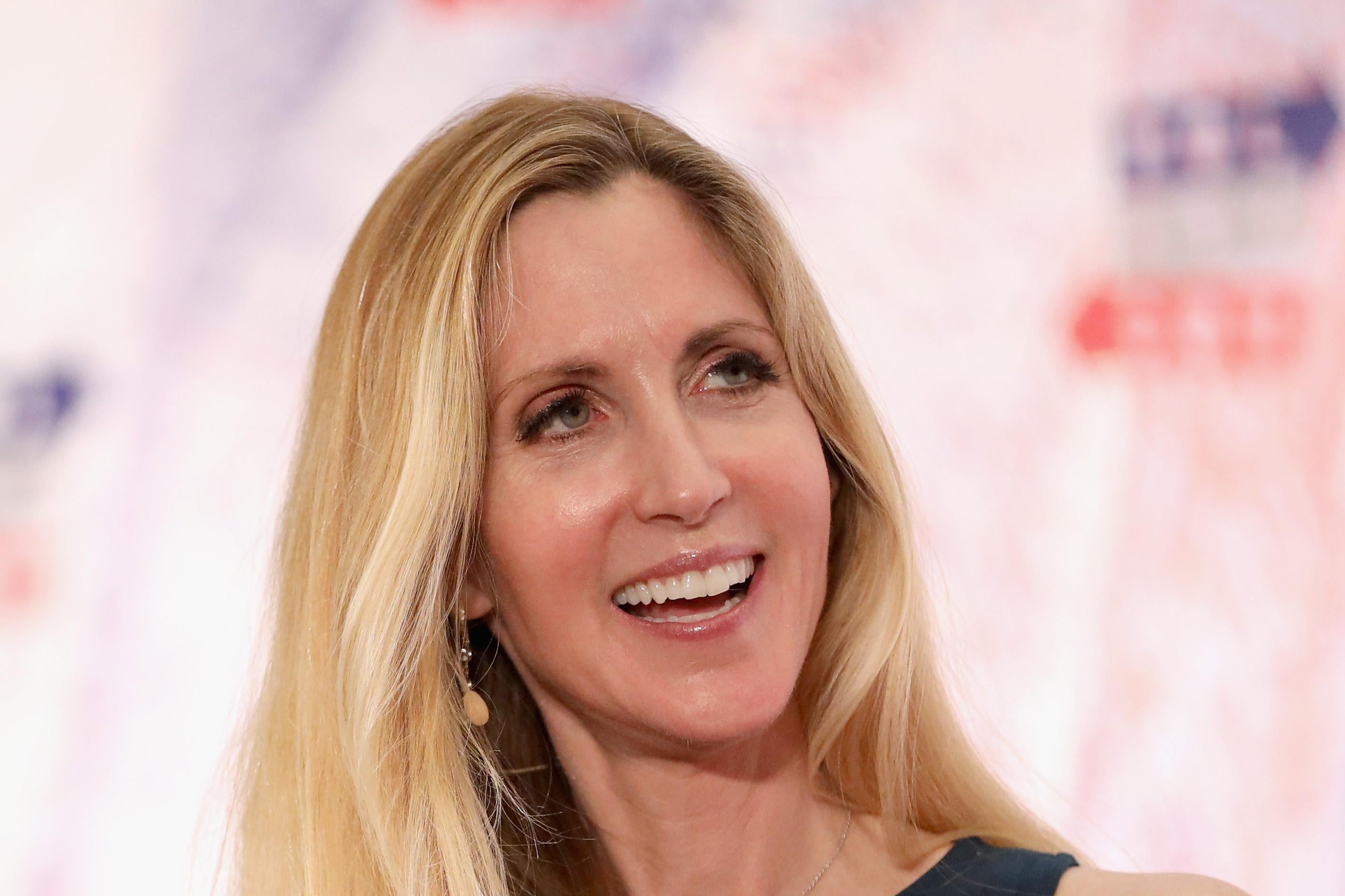 Ann Coulter smiles as she speaks onstage at a political convention.