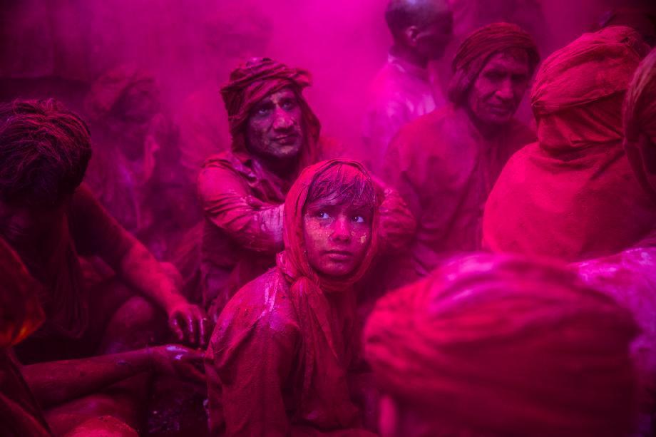 A boy looks on as Hindu devotees play with color during Lathmaar Holi celebrations on March 21, 2013 in the village of Barsana, near Mathura, India. 